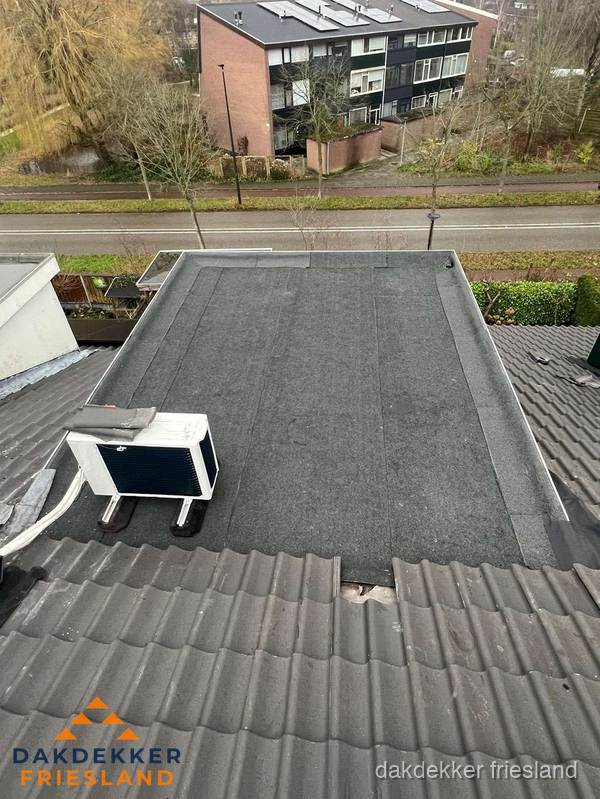 Plat dak inspectie met bitumen bedekking naast schuin pannendak in Friesland Plat dak inspectie met bitumen bedekking naast schuin pannendak in Friesland