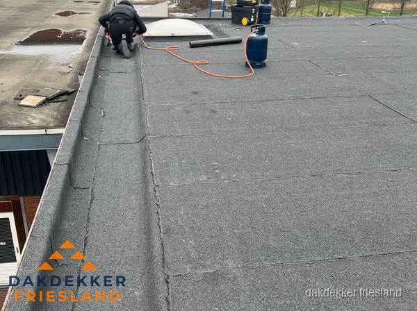 Dakdekker repareert bitumen dakbedekking op groot plat dak in Friesland Dakdekker repareert bitumen dakbedekking op groot plat dak in Friesland